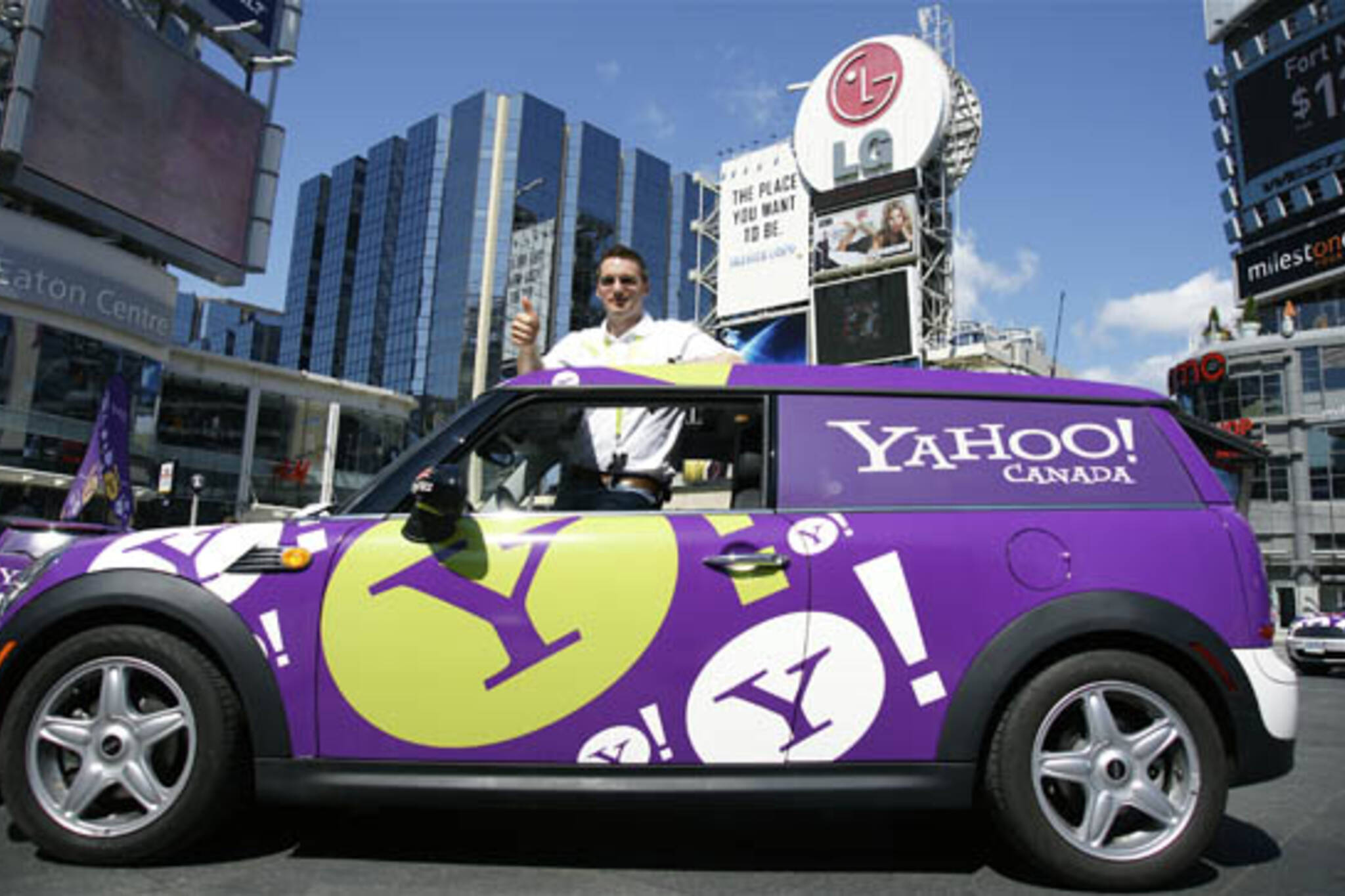 Andreas Kotal, President and CEO of CityFlitz pokes out of the sunroof of a MINI Clubmans during the launch of his auto-sharing service in the GTA today at Yonge-Dundas Square.