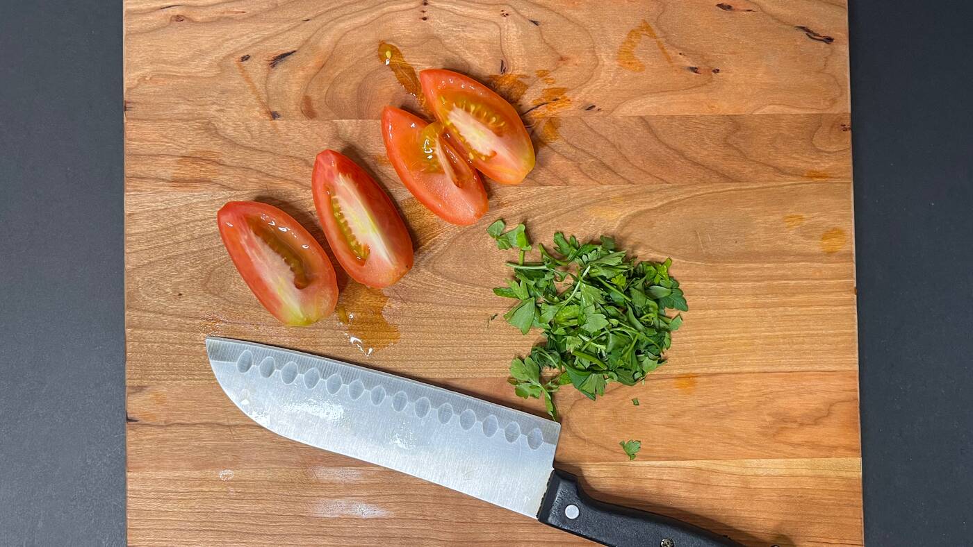 tomatoes and parsley on a cutting board